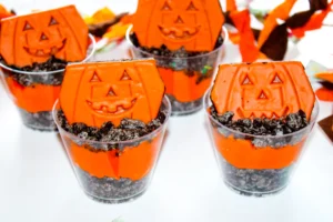 Halloween Dirt cups with crushed oreos, orange dyed pudding, and little debbie pumpkin brownies