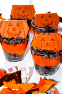 Halloween Dirt cups with crushed oreos, orange dyed pudding, and little debbie pumpkin brownies