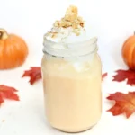 a Pumpkin Pie Milkshake in a mason jar topped with crushed graham crackers
