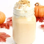 a Pumpkin Pie Milkshake in a mason jar topped with crushed graham crackers