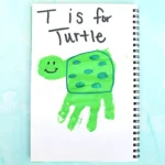 Notebook page showing a smiling green turtle drawing with the caption 'T is for Turtle'