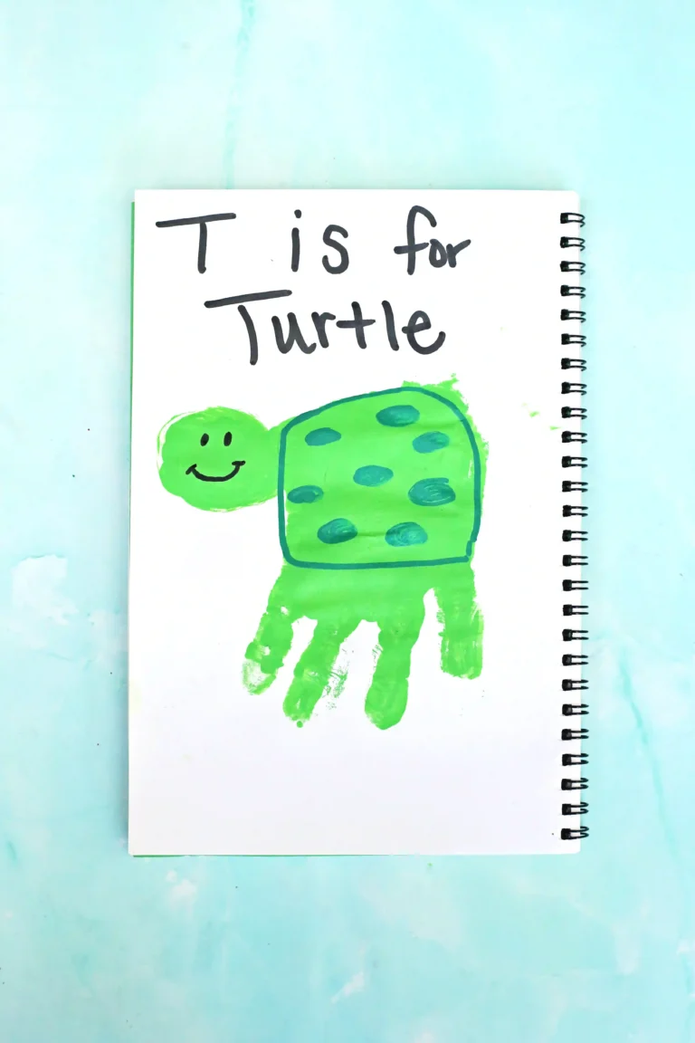 Notebook page showing a smiling green turtle drawing with the caption 'T is for Turtle'