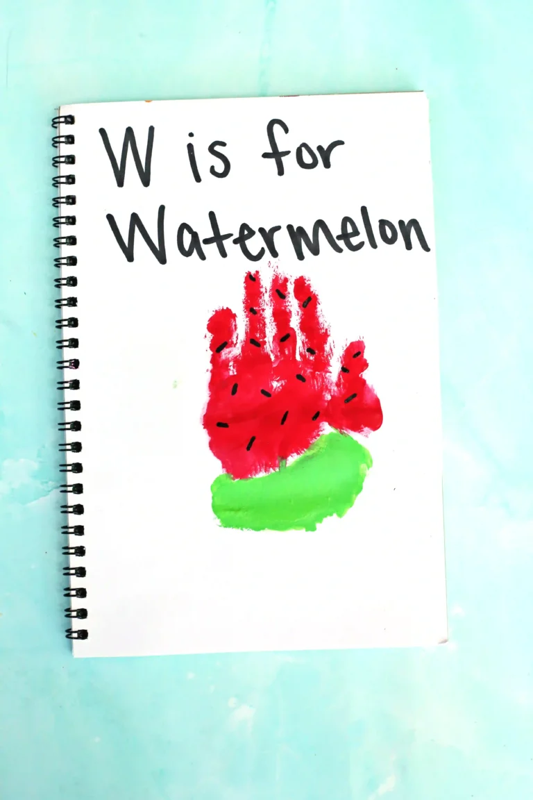 a watermelon handprint craft of a red and green handprint with watermelon seeds and words that read "w is for watermelon"