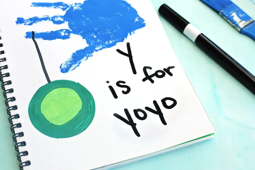 a blue handprint with a yoyo and words that read "y is for yo yo"