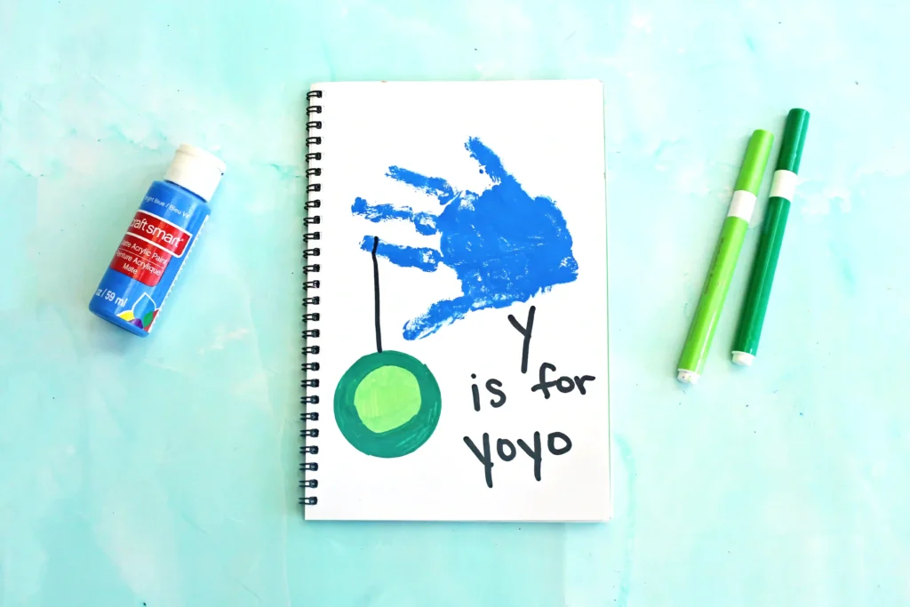 a blue handprint with a yoyo and words that read "y is for yo yo"